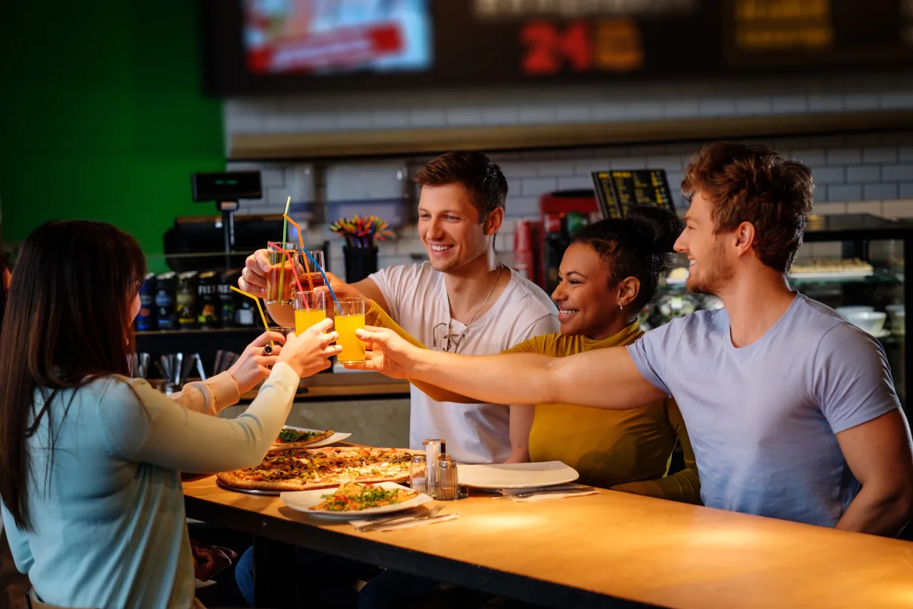 Klanten proosten aan een tafel met eten