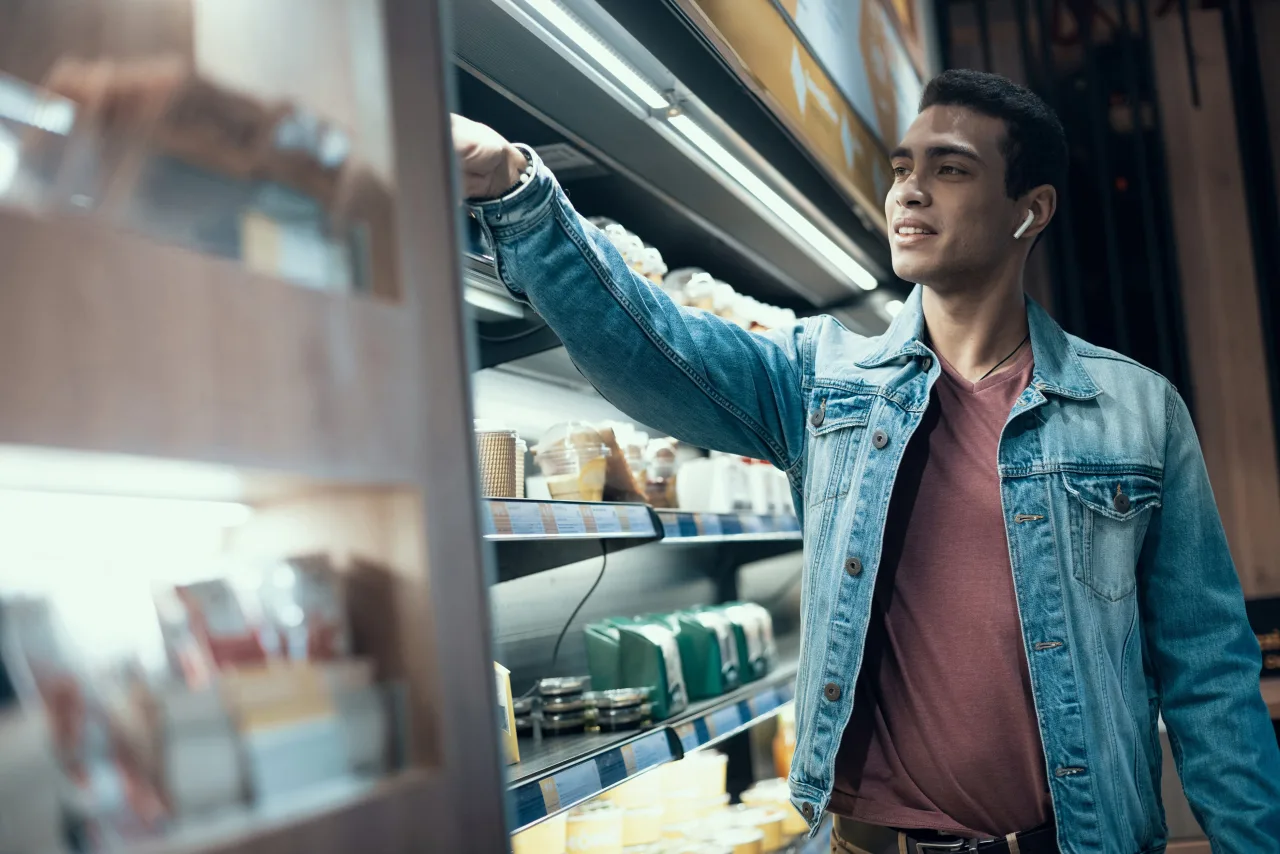 Klant pakt een product uit een gekoeld winkelschap