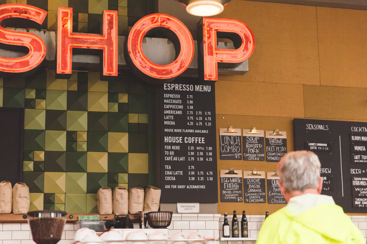 Neonbord met opschrift SHOP boven een espressobar